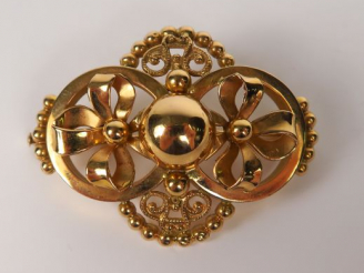 Vente aux enchères Broche en or jaune à décor de nœuds, perles et entrelacs. Poids : 5,2 