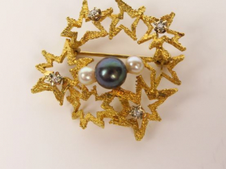 Vente aux enchères Broche en or à décor d'étoiles stylisées, ornée d'une perle grise épau