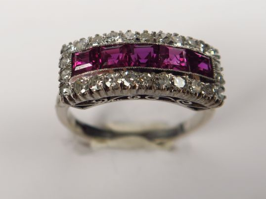 Bague en or, ornée de rubis calibrés dans un entourage de petits diama