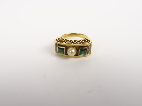 Bague 'spirale' ornée de pierres rouges. Monture en métal doré