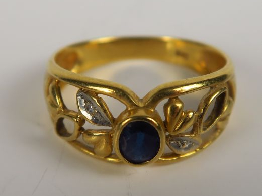 Bague en or sertie d'un saphir, monture ajourée à motif de feuillage. 