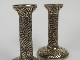 Vente aux enchères 	Paire de bougeoirs en argent, à décor de feuillage. Travail étranger.