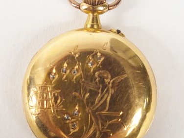 TRILLA. Petite montre savonnette en or jaune, décor gravé d'ange et de