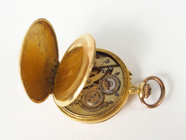 TRILLA. Petite montre savonnette en or jaune, décor gravé d'ange et de