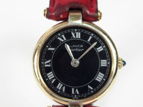 Vente aux enchères CARTIER, "les must". Montre de dame, boitier rond en plaqué or, fond n