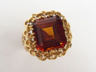 Vente aux enchères Bague 1900 en or jaune ajourée, ornée d’une topaze orange taille carré