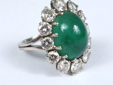 Bague marguerite ornée d'une émeraude en cabochon, dans un entourage d