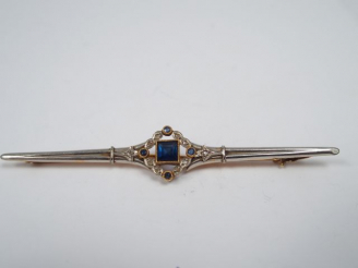 Vente aux enchères Broche Art Déco en or jaune et blanc, ornée d'un saphir central entour