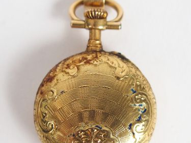 Montre de col en or jaune, cadran émail, chiffres romains, décor d'ara