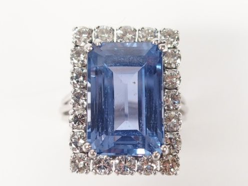 Bague en or blanc, ornée d'un saphir synthétique, entourage de 20 diam