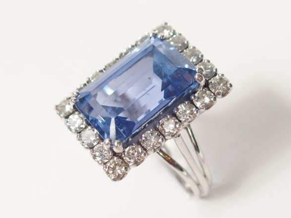 Bague en or blanc, ornée d'un saphir synthétique, entourage de 20 diam