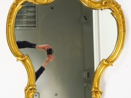 Miroir de style Louis XV de forme violonée en bois et stuc doré, à déc