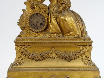 Pendule Restauration en bronze doré figurant une jeune femme romantiqu