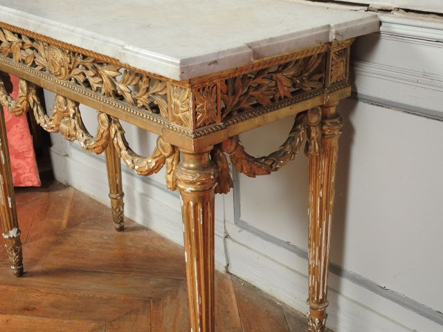 	Console Louis XVI en bois sculpté et doré à quatre pieds cannelés, à 