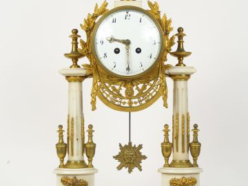 Pendule portique de style Louis XVI en marbre blanc et bronze doré.  H