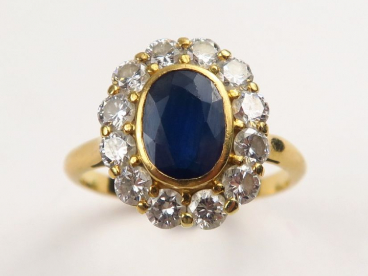 Bague marguerite, saphir serti clos dans un entourage de diamants.  TD