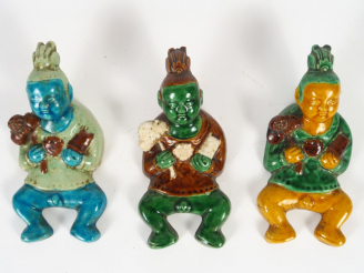 Vente aux enchères Trois appliques en céramique émaillée, à décor de jeune enfant tenant 