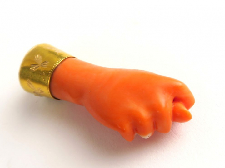 Pendeloque en corail, monture en or, figurant une main. Longueur : 4,5