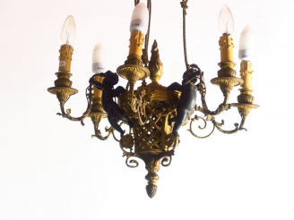 Vente aux enchères 	Lustre de style Louis XVI en bronze patiné et ajouré, à décor d’amour