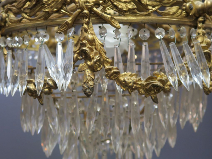Lustre 1900 de style Louis XVI en bronze doré et cristal.  Eclairant à