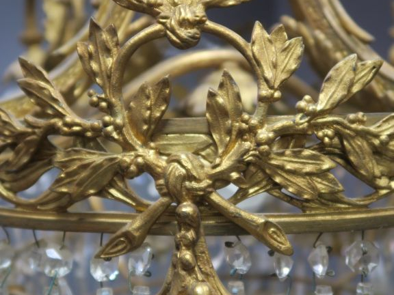 Lustre 1900 de style Louis XVI en bronze doré et cristal.  Eclairant à