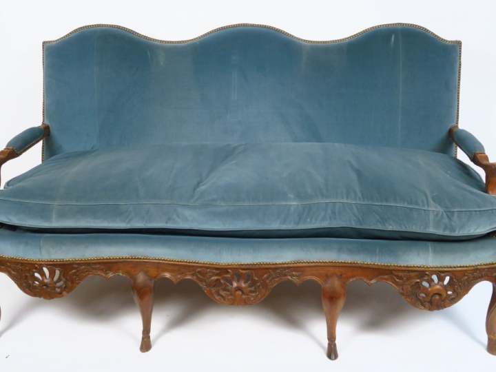 	Canapé Régence en noyer mouluré et sculpté, huit pieds terminés en sa