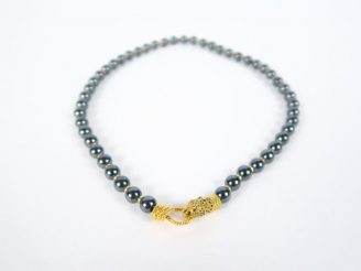 Vente aux enchères Collier de 49 perles grises, séparées par de petites perles en or. Bea