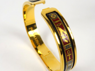 Vente aux enchères Fery WILLE. Bracelet jonc en métal doré à décor égyptine.