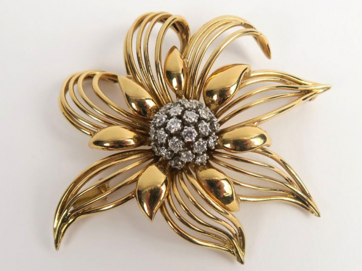 Broche en or, en forme de fleur stylisée, sertie en son centre de diam