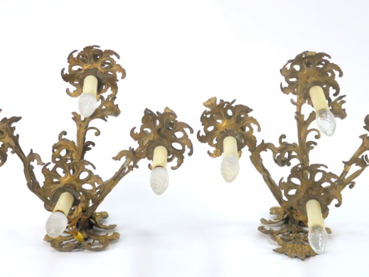Paire d'appliques de style rocaille en métal doré. Eclairant à quatre 