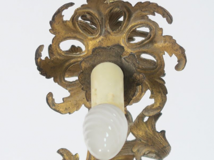 Paire d'appliques de style rocaille en métal doré. Eclairant à quatre 