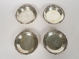 Vente aux enchères CHRISTOFLE.  Quatre dessous de bouteille de style Louis XV en métal ar