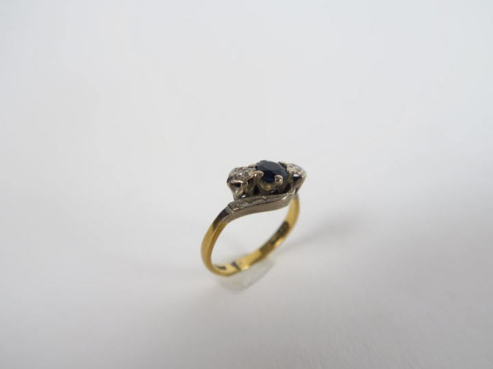 Bague deux tons d'or, sertie d'un saphir épaulé d'éclats de diamants. 