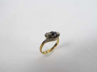 Vente aux enchères Bague deux tons d'or, sertie d'un saphir épaulé d'éclats de diamants. 