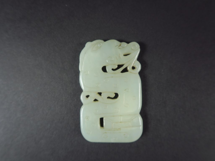 Pendentif en jade blanc celadon, à décor double faces d'un dragon assi