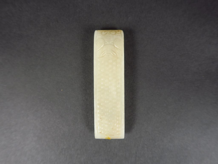 Agraphe en jade céladon, à décor d'une tête d'animal stylisé.  Chine, 