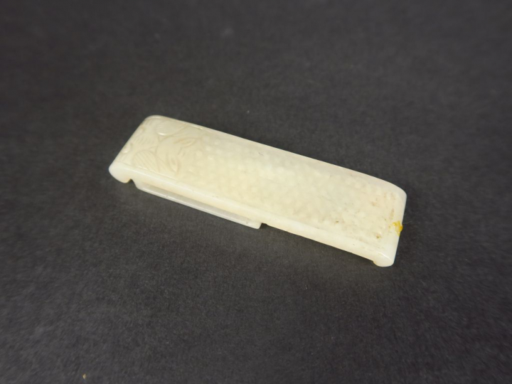 Agraphe en jade céladon, à décor d'une tête d'animal stylisé.  Chine, 