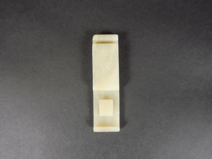 Agraphe en jade céladon, à décor d'une tête d'animal stylisé.  Chine, 