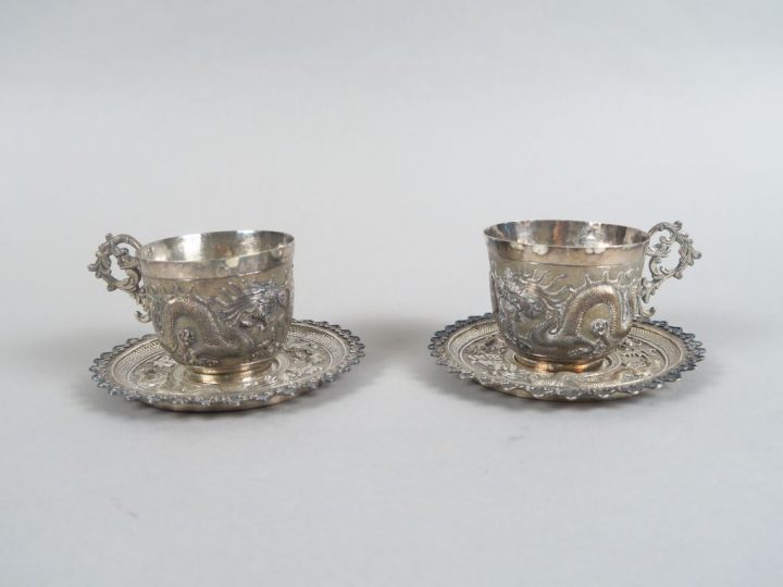 Paire de tasses et sous-tasses en argent bas-titre, à décor finement c