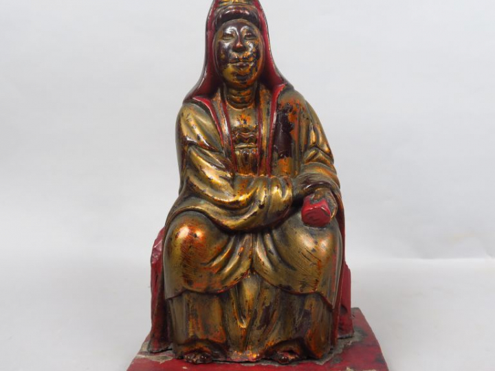 Sujet en bois laqué or et rouge représentant Guanyin assise tenant le 