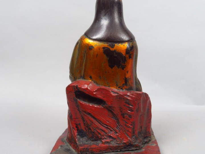Sujet en bois laqué or et rouge représentant Guanyin assise tenant le 