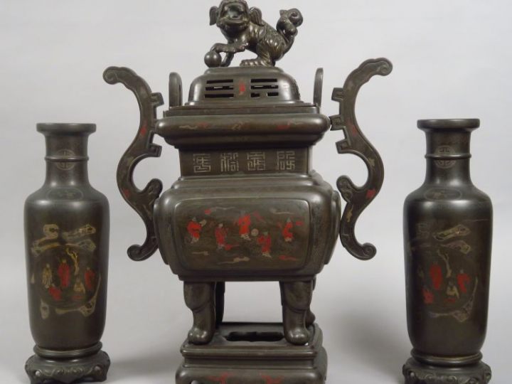 Garniture en bronze niellé d'argent et d'émaux polychromes comprenant 