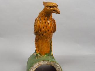 Vente aux enchères Tuile faitière en céramique émaillée ocre et vert, représentant un phé