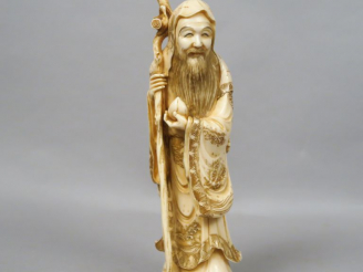 Vente aux enchères Okimono en ivoire représentant Jurojin tenant un rouleau et une pêche 