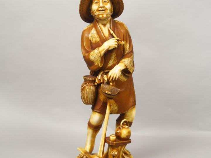 Okimono en ivoire de patine contrastée, représentant un paysan au repo