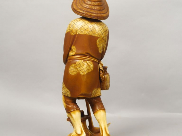 Okimono en ivoire de patine contrastée, représentant un paysan au repo