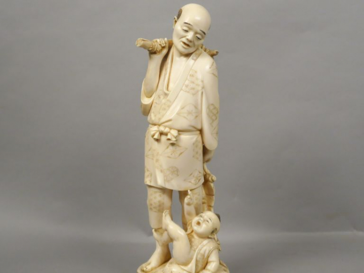 Okimono en ivoire représentant un paysan portant une besace, regardant