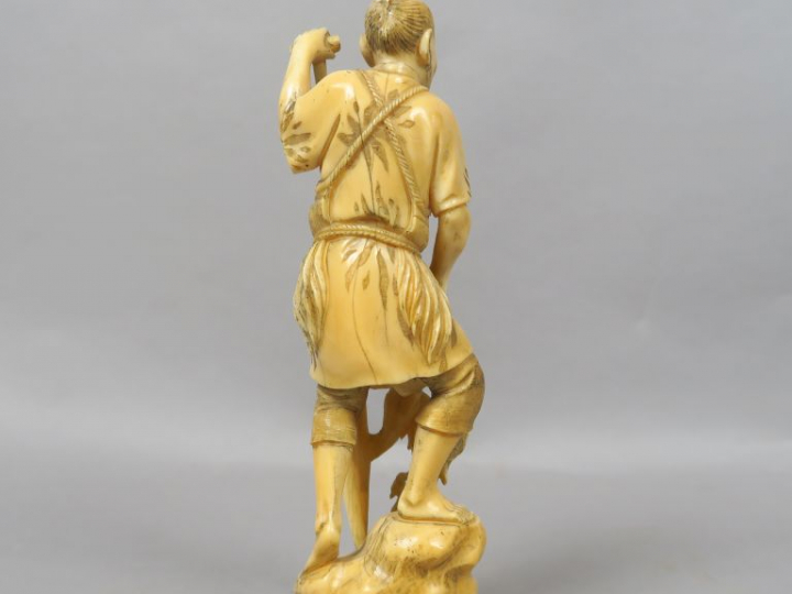 Okimono en ivoire représentant un pêcheur appuyé à une rame. Japon, ve