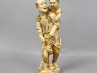 Vente aux enchères Okimono en ivoire représentant un père et son fils s’amusant avec un j