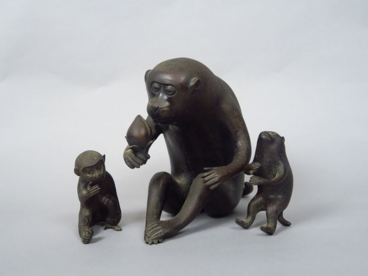 Okimono en bronze de patine brune représentant un singe assis, s’apprê